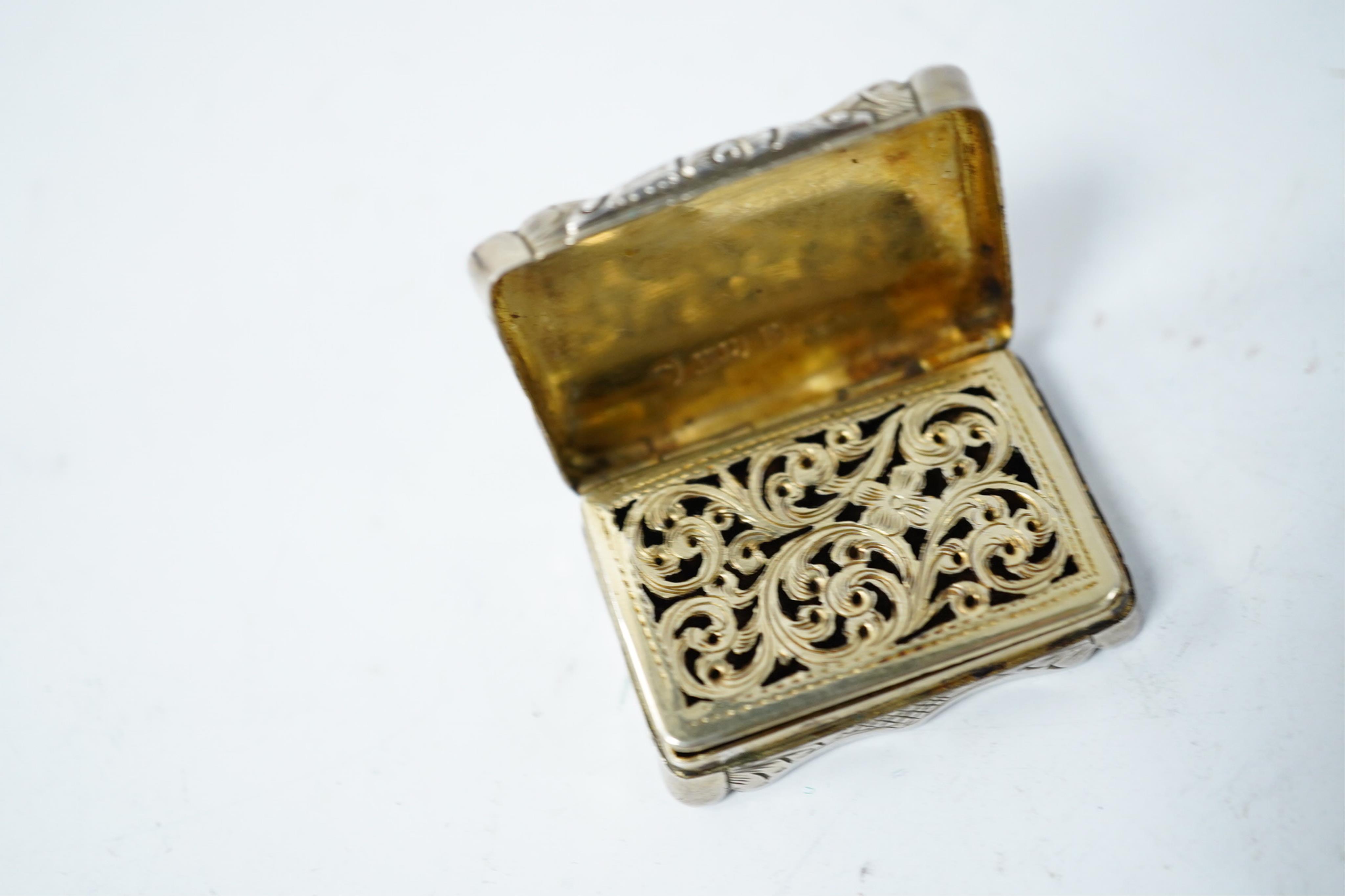 A Victorian silver shaped rectangular vinaigrette, engraved with a scene to commemorate The Great Exhibition at the Crystal Palace in Hyde Park, London, by William Dudley, Birmingham, 1850, 33mm, together with three smal